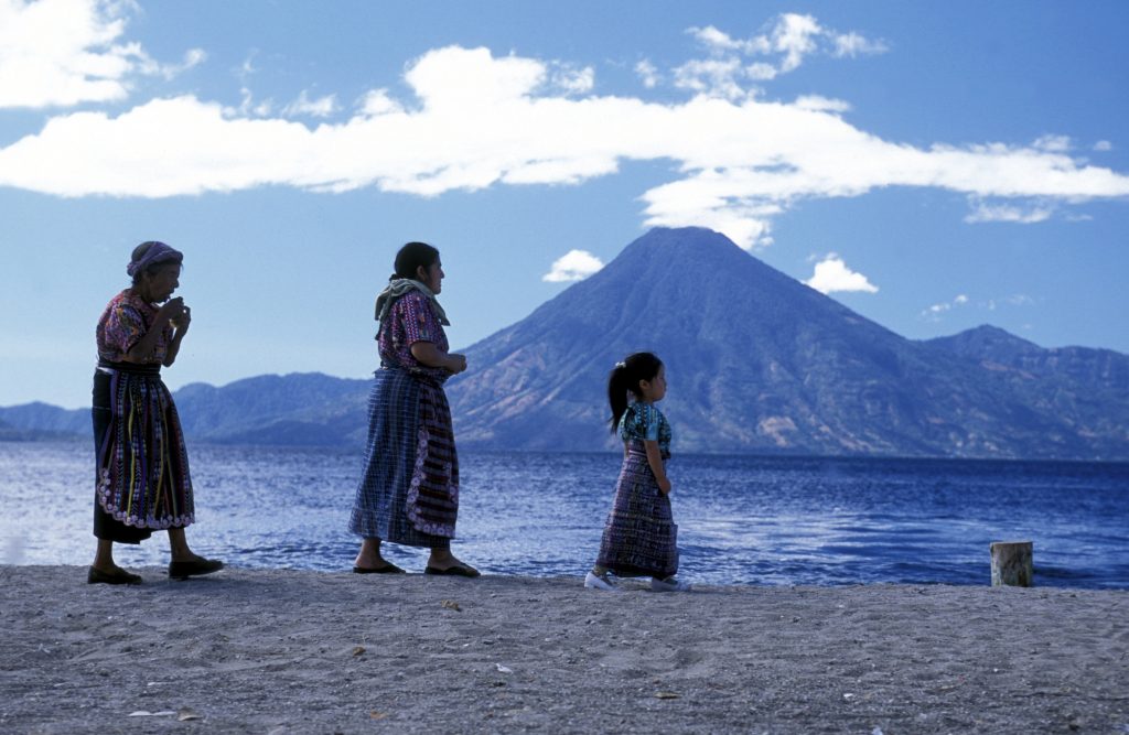 People at the coast of Lake Atitlan mit the Volcanos of Toliman and San Pedro in the back at the Town of Panajachel in Guatemala in central America.