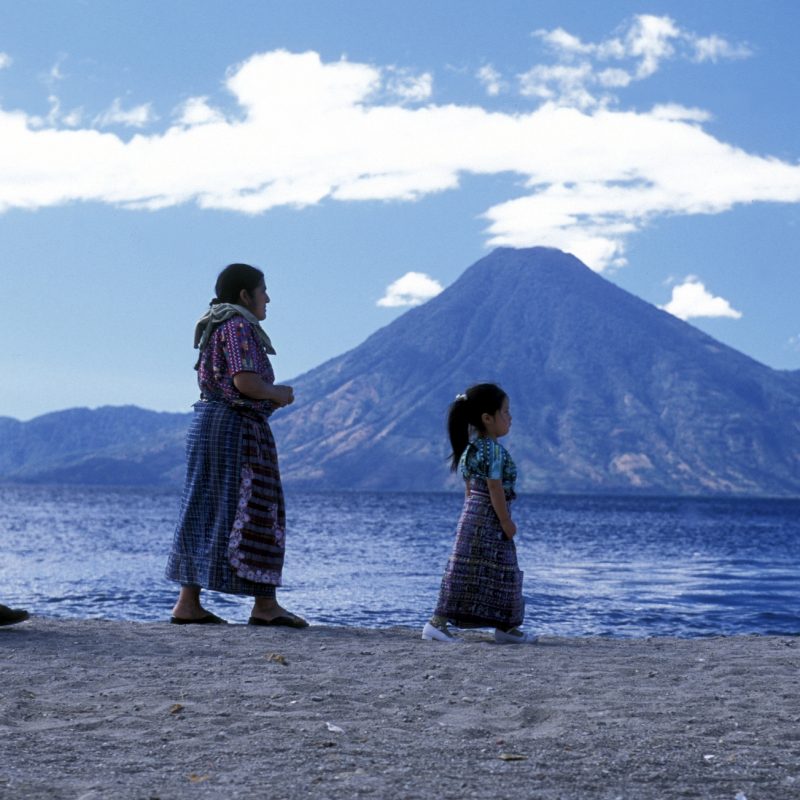 People at the coast of Lake Atitlan mit the Volcanos of Toliman and San Pedro in the back at the Town of Panajachel in Guatemala in central America.