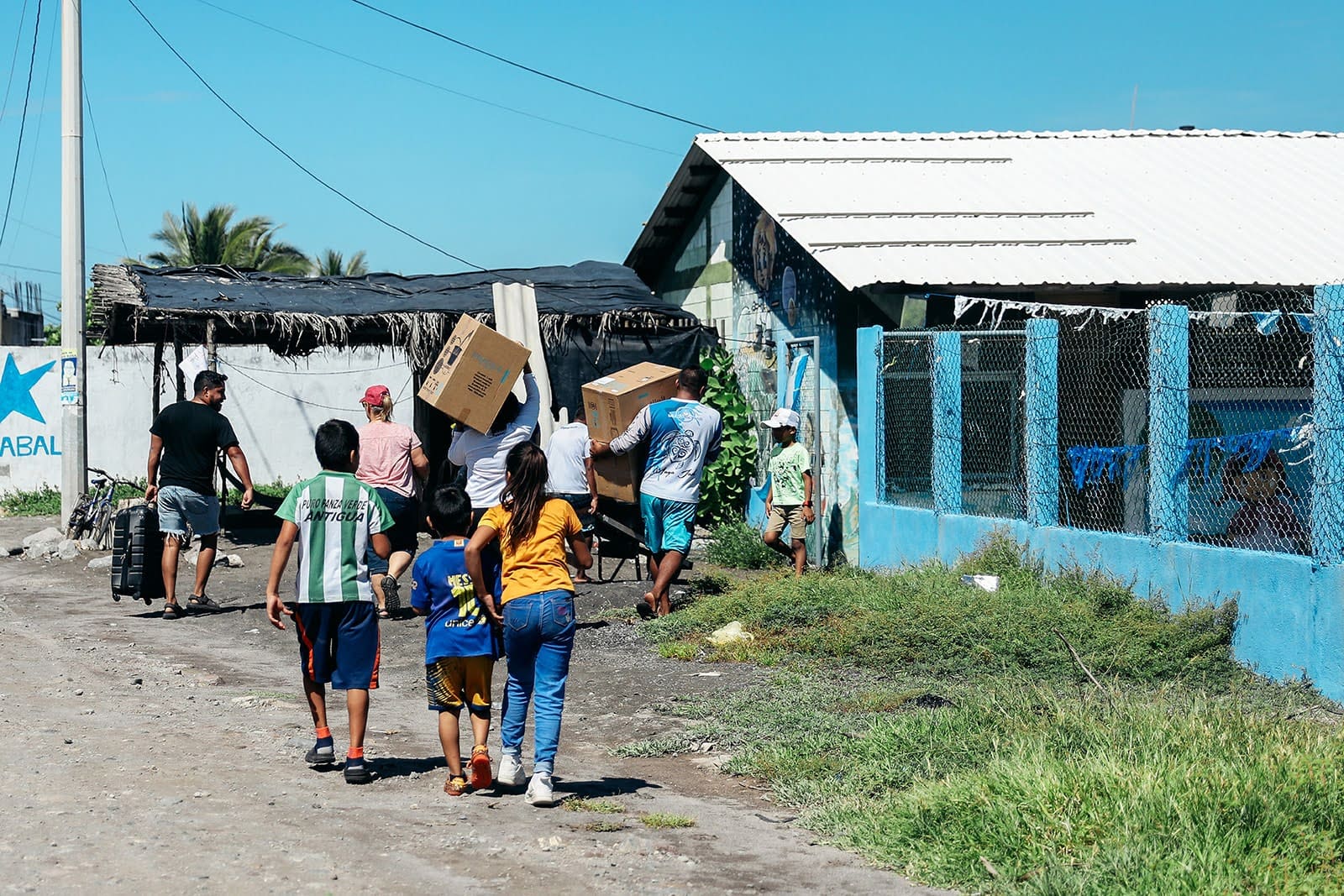 Group joining best volunteer vacation programs Guatemala, carrying water filters and donations to a coastal community center. 