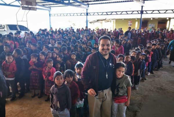 Man with students during an outreach event for the best Guatemala volunteer vacation programs for seniors.