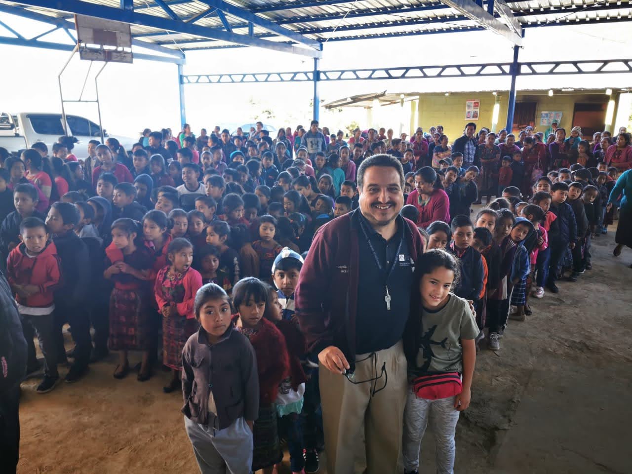 Man with students during an outreach event for the best Guatemala volunteer vacation programs for seniors.