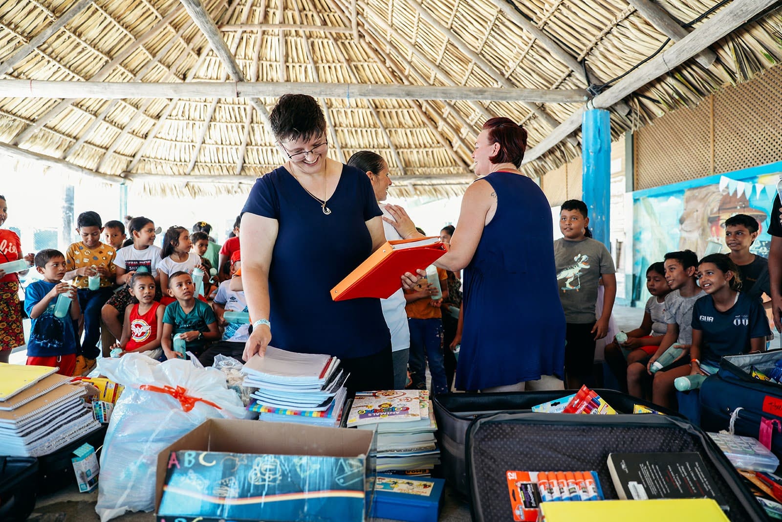 Top senior volunteer travel opportunities in Guatemala: volunteers sorting school supplies for children at a community gathering. 