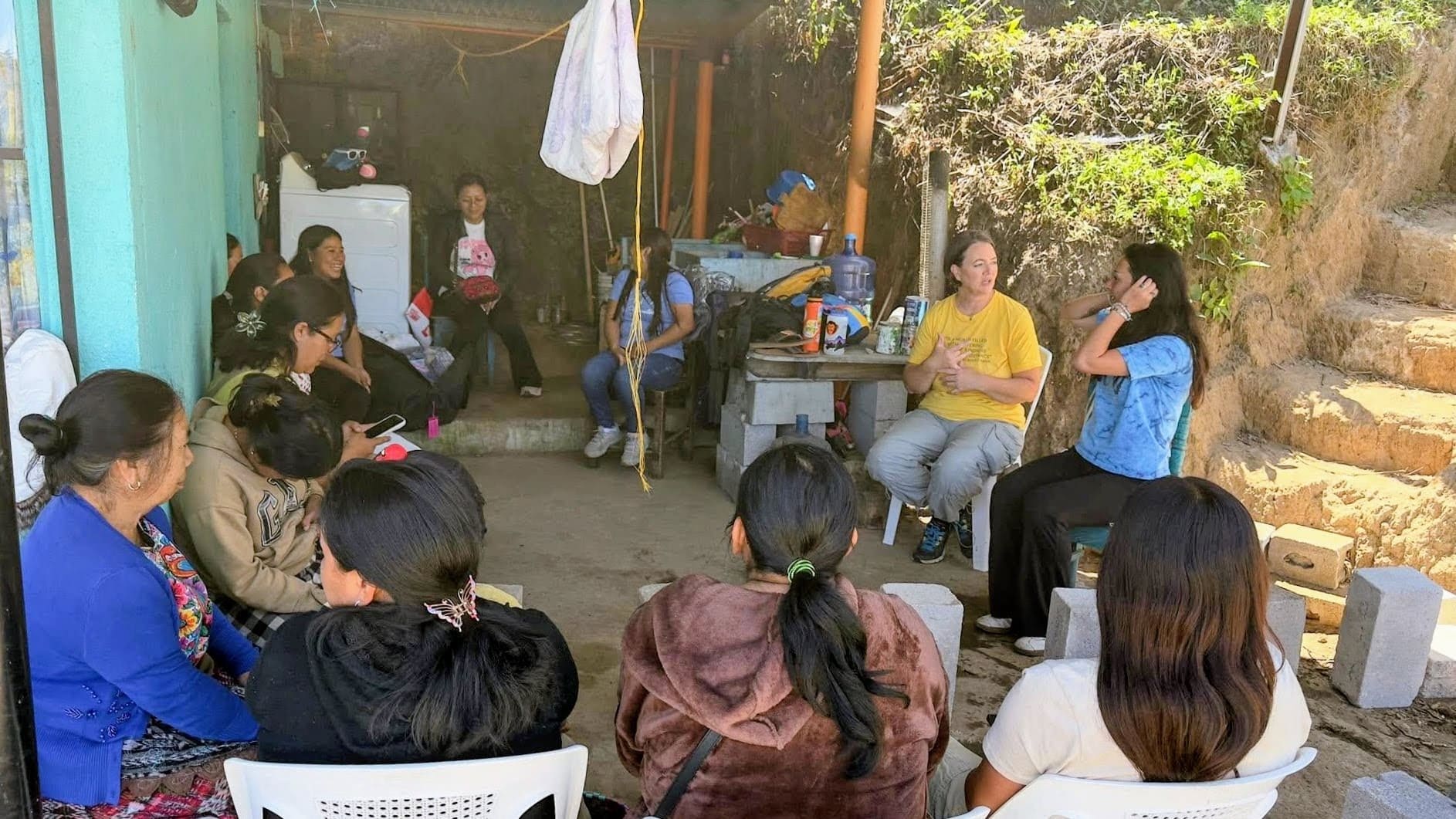 Outdoor community meeting demonstrating local customs etiquette Guatemala volunteers observe while listening 