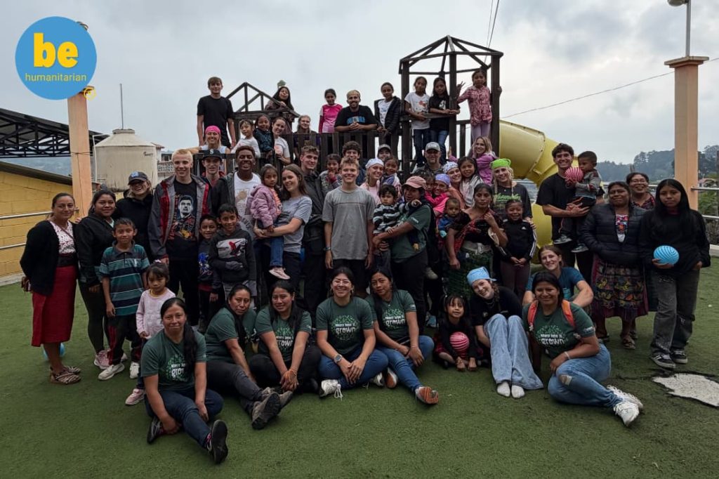 Large volunteer and community group photo on a playground showing what to expect volunteering in Guatemala