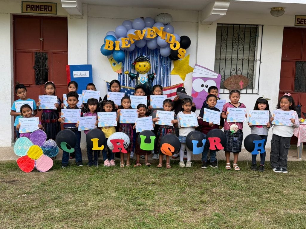 Children holding certificates at a graduation, part of what to expect sponsoring child Guatemala programs 
