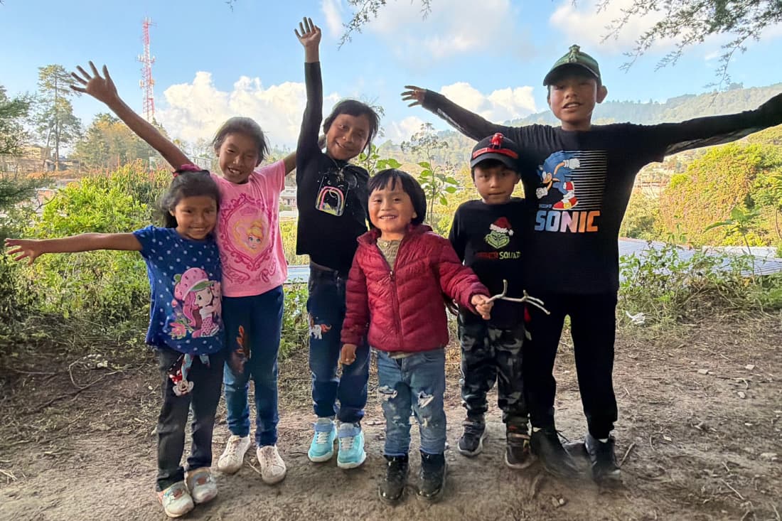 Joyful Guatemalan children cheering outdoors capturing the emotional benefits sponsoring child Guatemala