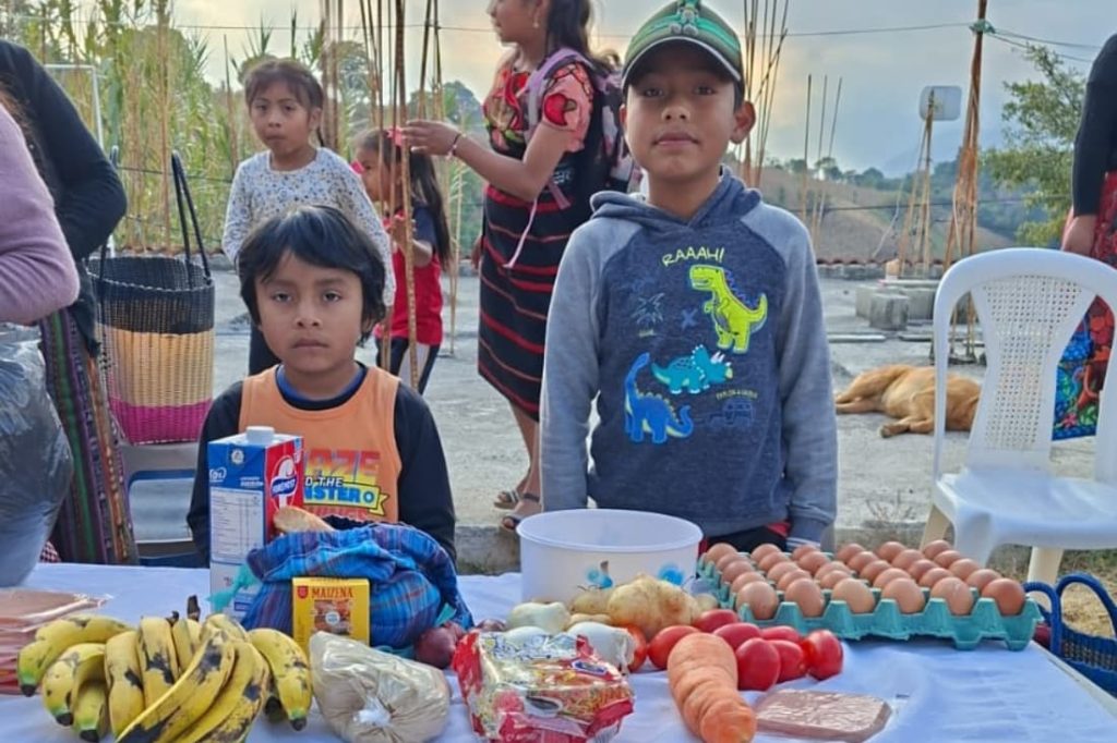 Two Guatemalan boys with nutritious food supplies distributed to improve food security volunteer Guatemala