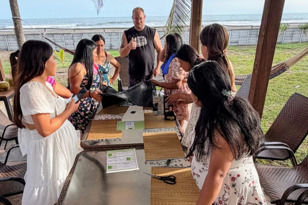 Volunteers and locals working together at a beachside workshop reflecting emotional benefits sponsoring child Guatemala