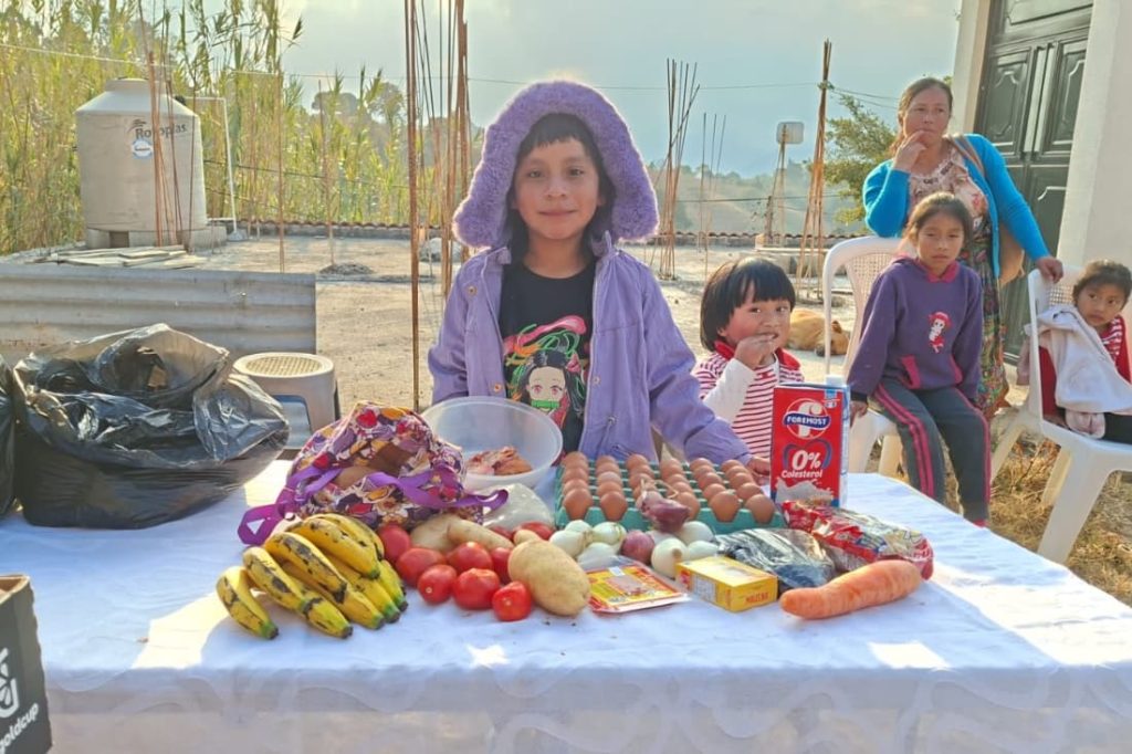 Young Guatemalan children with fresh produce and eggs received to improve food security volunteer Guatemala