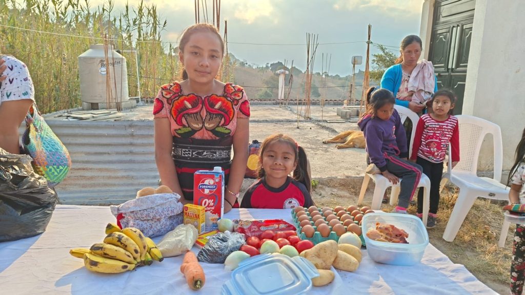 Girl with fresh food supplies reflects what is Sustainable Guatemala volunteer impact on nutrition