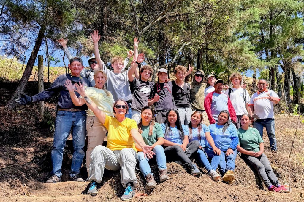 Volunteers and community members celebrate what is Sustainable Guatemala volunteer impact outdoors 