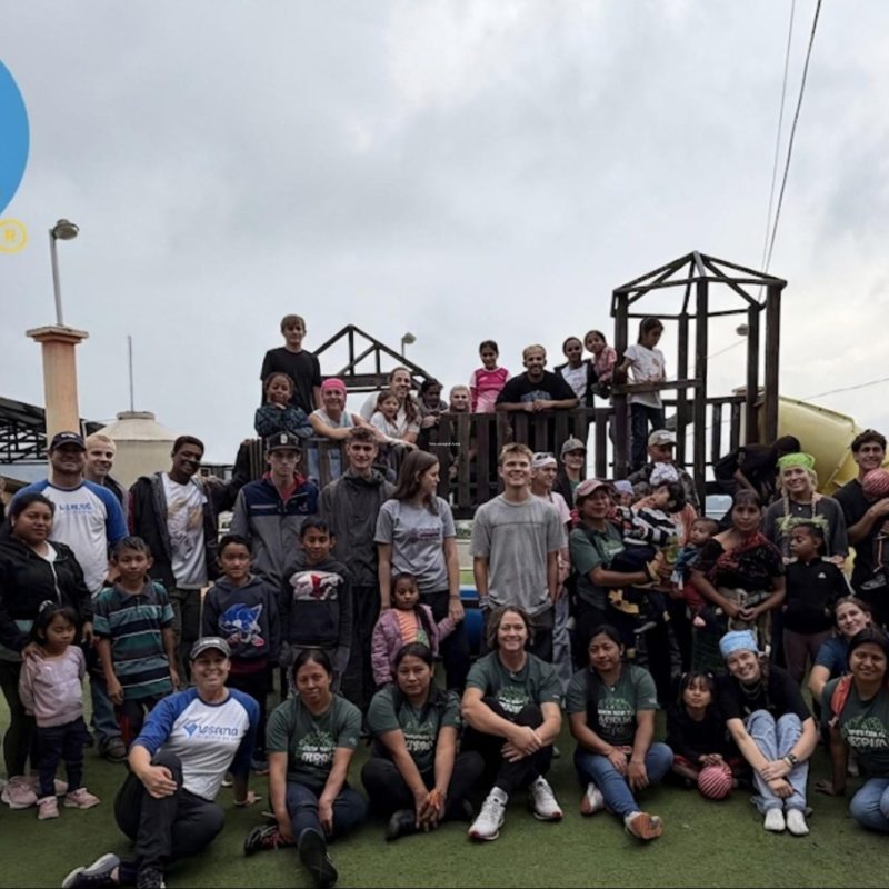 Volunteers and local community posing outdoors at a Guatemala playground, book ethical volunteer trips in guatemala