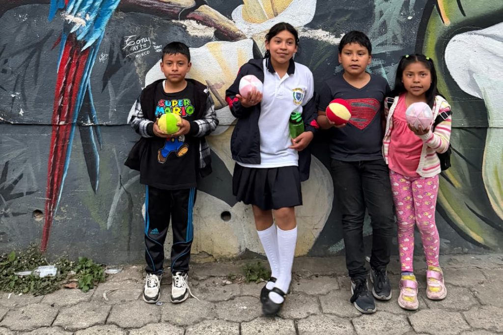 Corporate CSR retreat volunteer trip Guatemala brings local children donated balls near mural