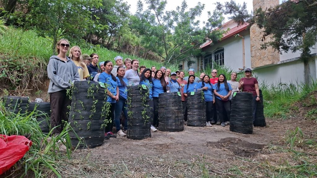 Volunteers and locals plant trees together, showing how volunteer vacations impact rural Guatemala's environment. 