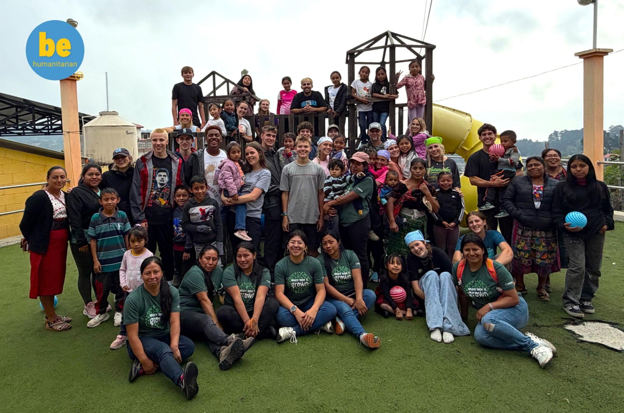 Volunteers and children smile together outdoors, showing what impact do Guatemala volunteers make in local communities.